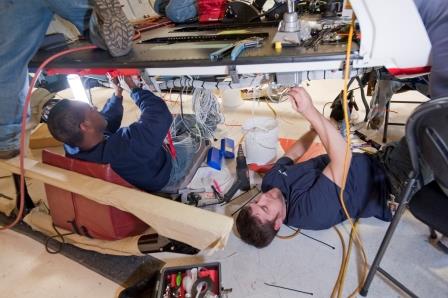 Installation crew installing hardware in helicopter. 